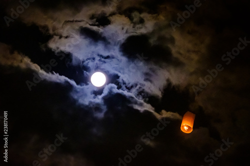 Foto Sky lantern passing by the moon during Yi Peng festival in Chiang Mai, Thailand