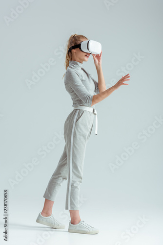 girl in grey clothing gesturing on grey background photo