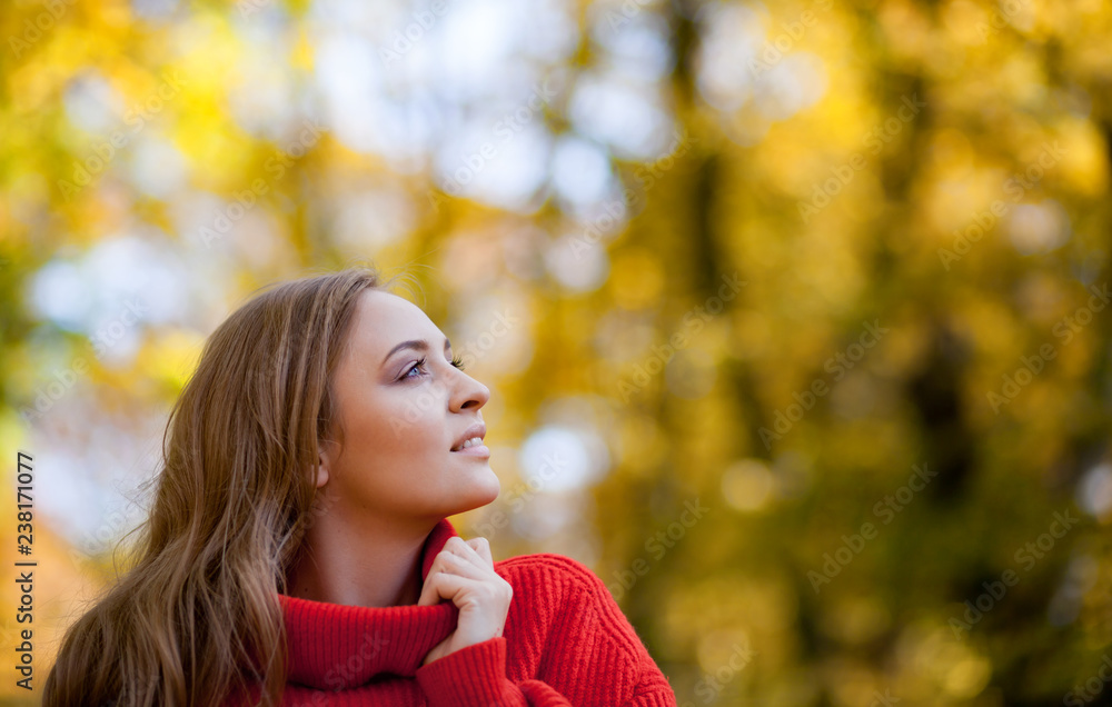Beautiful smiling young woman in soft knitted sweater walking outdoor, positive feelings Beautiful smiling young woman in soft knitted sweater walking outdoor, positive feelings