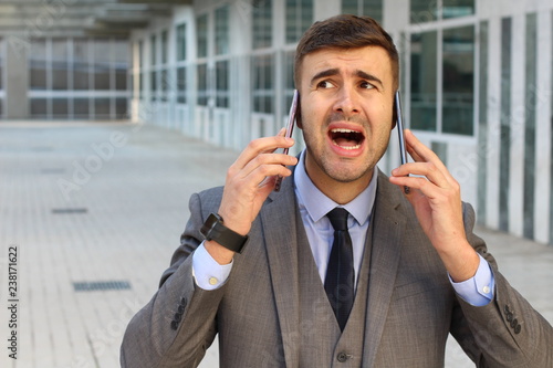 Overwhelmed businessman during double call 