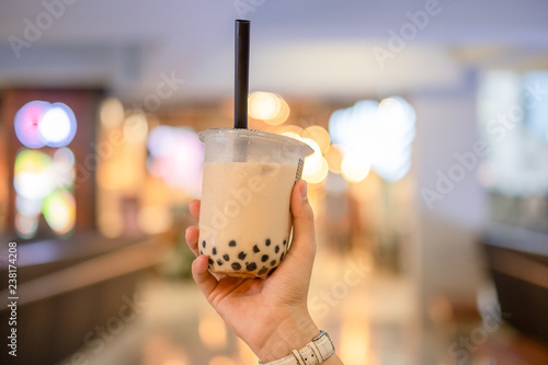 Obraz na plátně woman hand holding iced milk bubble tea with tapioca pearls, traditional drink o