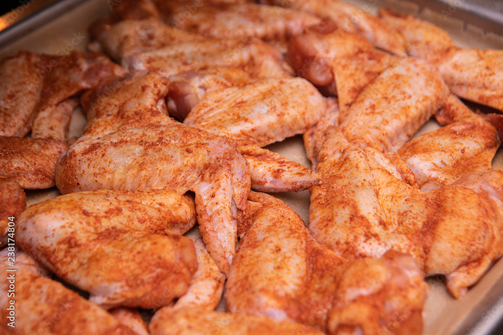 Chicken wings. Raw poultry meat with spices on a baking sheet