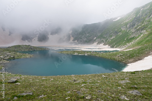 fog falls on a mountain glacial lake. Lake Chilick, Caucasus mountains, resort area Arkhyz