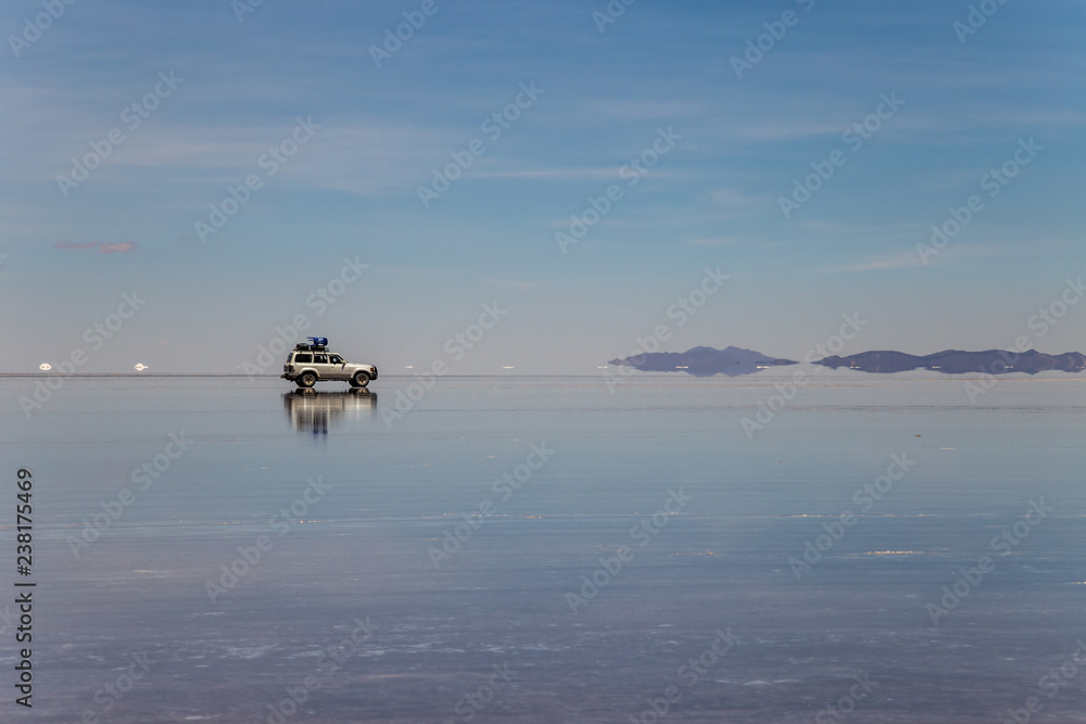 Car crossing the largest salt flat in the world. Uyuni, Bolivia Car crossing the largest salt flat in the world. Uyuni, Bolivia