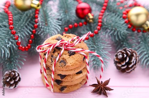 Chocolate cookies and christmas decoration on pink wooden background
