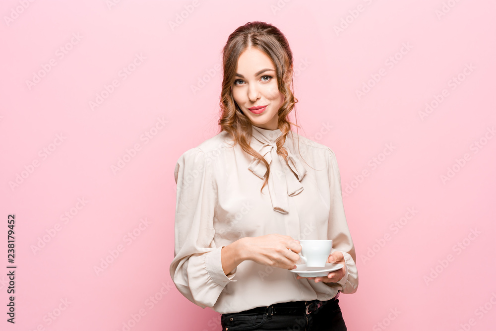 Fototapeta premium The serious frustrated young beautiful business woman with empty cup on pink studio background