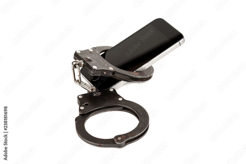 Obraz premium phone and the handcuffs. the concept of dependence on the Internet,technology and social networks. isolated on white background.