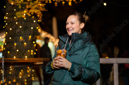 Happy woman holding traditional food at Christmas market. Zagreb, Croatia photo