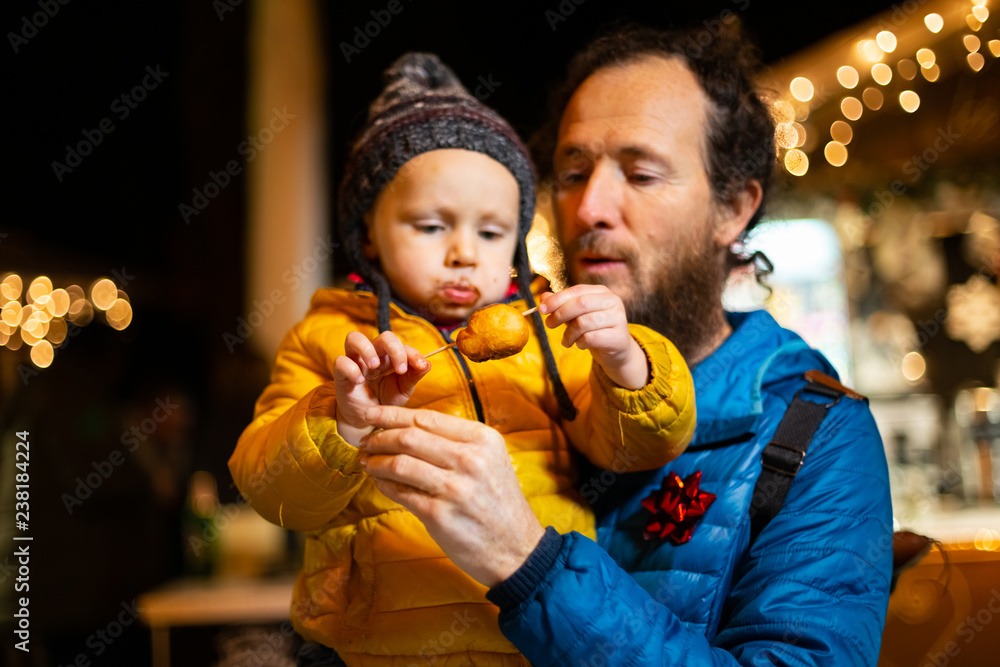 Portrait of father holding son at Christmas market in Zagreb, Croatia.