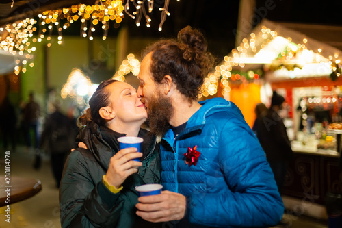Couple kissing and enjoying traditional Christmas market, Zagreb, Croatia.
