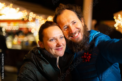 Portrait of couple taking selfie, traditional Christmas market, Zagreb, Croatia.