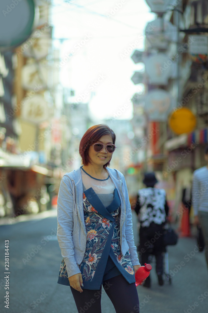 asian woman toothy smiling face standing in dotonbori street one of most popular traveling destination in  osaka japan