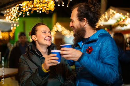 Couple enjoying traditional drink at Christmas market, Zagreb, Croatia.