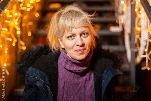 Portrait of woman sitting on stairs at Christmas market.