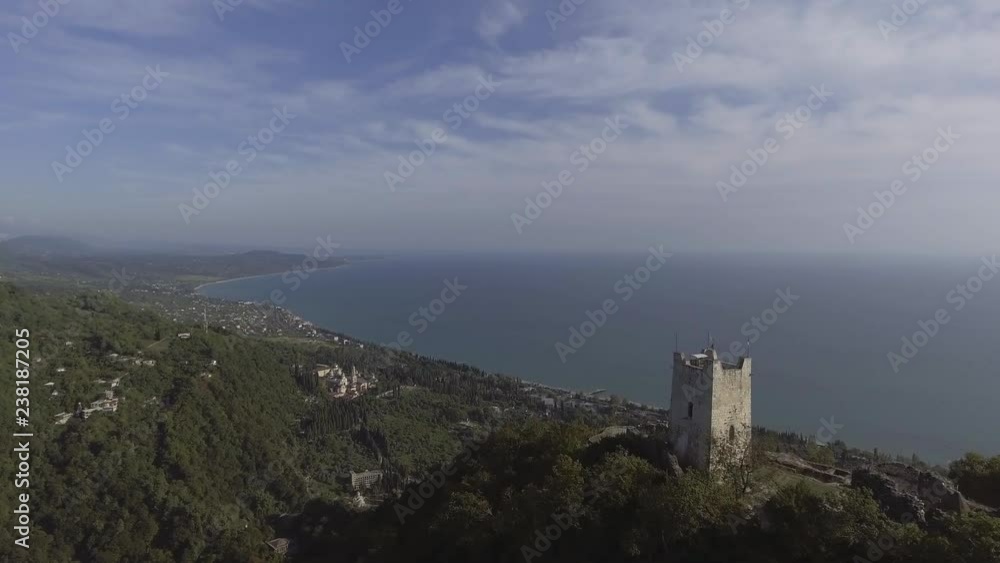Drone shows old beauty of Anacopia Fortress in Abkhazia and amazing Black Sea with long shore coast line connecting with valley and green hills on summer sunny day with amazing blue sky. Drone shows old beauty of Anacopia Fortress in Abkhazia and amazing Black Sea with long shore coast line connecting with valley and green hills on summer sunny day with amazing blue sky.