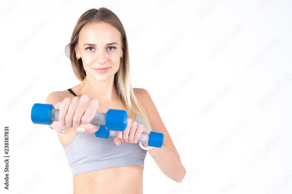 Beautiful young slim girl with dumbbells on a white background. Novice athlete Beautiful young slim girl with dumbbells on a white background. Novice athlete