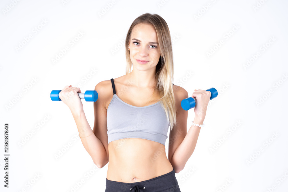 Beautiful young slim girl with dumbbells on a white background. Novice athlete Beautiful young slim girl with dumbbells on a white background. Novice athlete