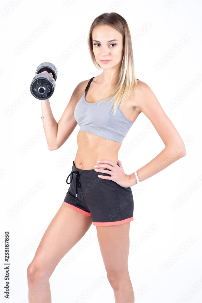 Beautiful young slim girl with dumbbells on a white background. Novice athlete Beautiful young slim girl with dumbbells on a white background. Novice athlete