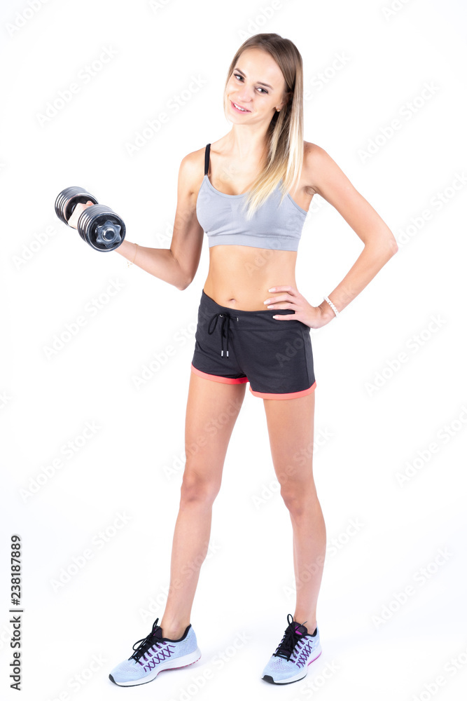 Beautiful young slim girl with dumbbells on a white background. Novice athlete Beautiful young slim girl with dumbbells on a white background. Novice athlete