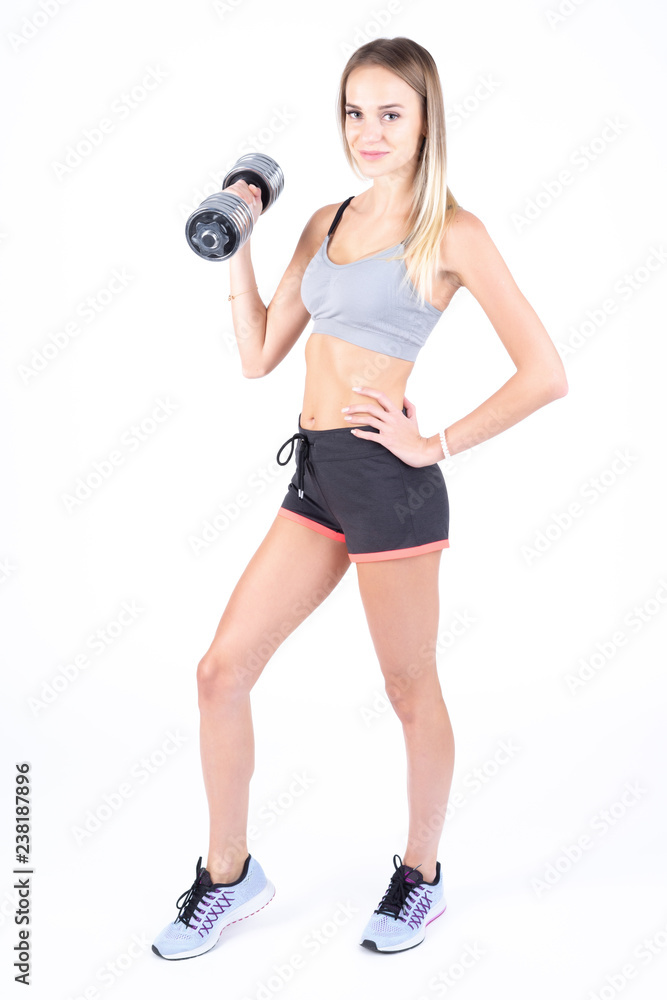 Beautiful young slim girl with dumbbells on a white background. Novice athlete Beautiful young slim girl with dumbbells on a white background. Novice athlete
