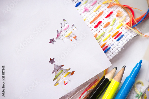 Creative workshop for kids. Sharp coloured drawing pencils, markers on table. Embroidery fabric with hand embroidered colorful elements. Kids learning to do creative crafts at school, cut decorations.