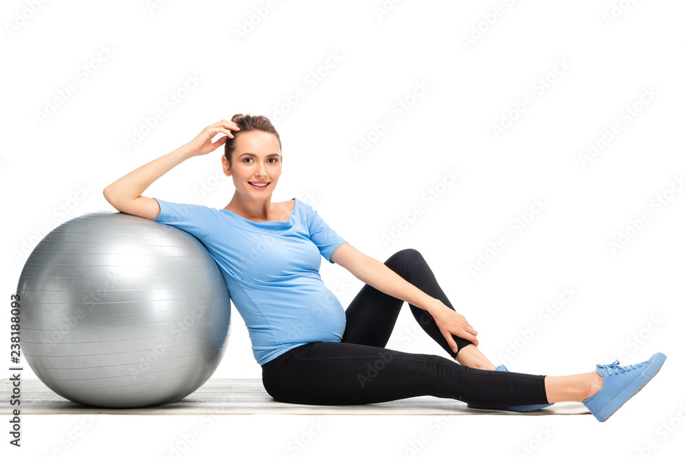 Fototapeta premium brown haired pregnant woman sitting on floor with grey fitness ball isolated on white