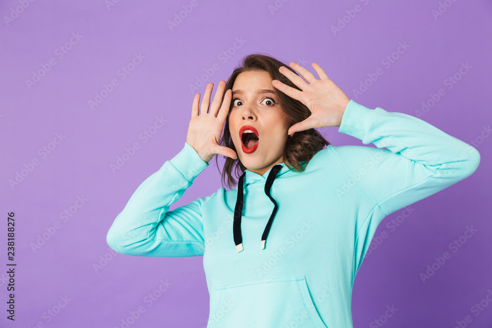 Shocked emotional young woman posing isolated over purple background wall. Shocked emotional young woman posing isolated over purple background wall.