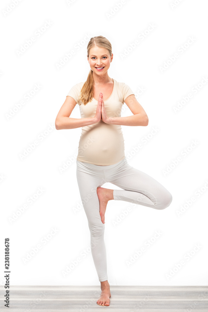 full length of pregnant blonde standing in tree pose isolated on white full length of pregnant blonde standing in tree pose isolated on white