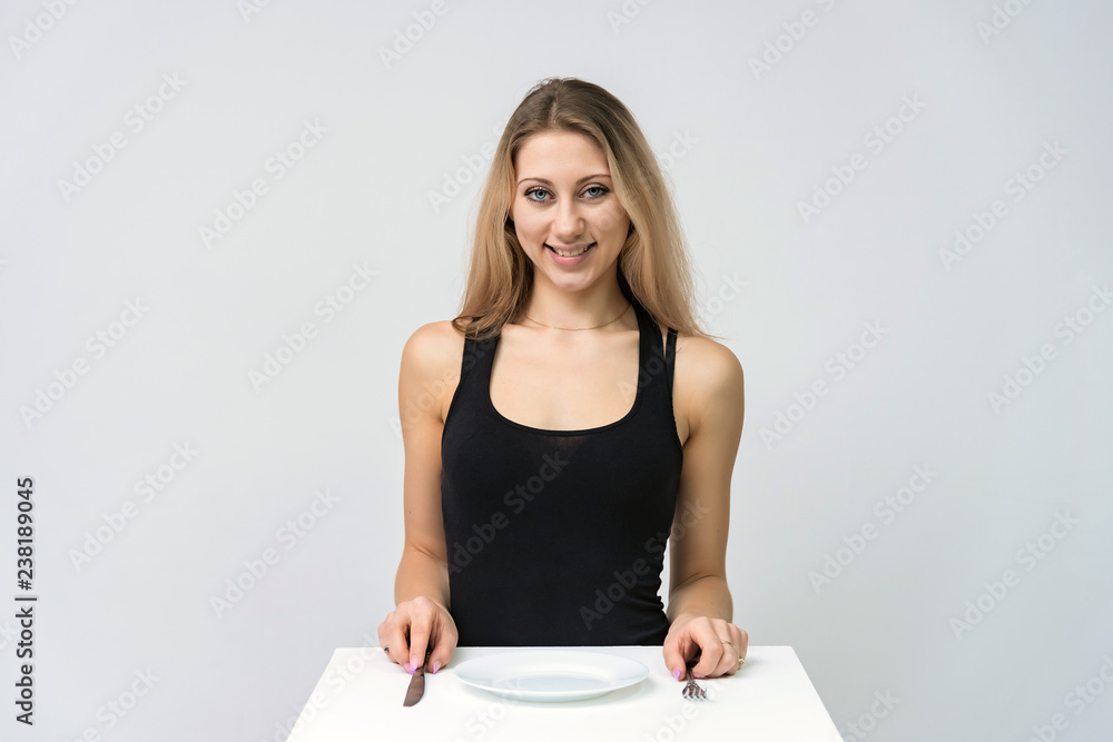 Concept portrait of a beautiful blonde girl eating smiling at a table. Concept portrait of a beautiful blonde girl eating smiling at a table.