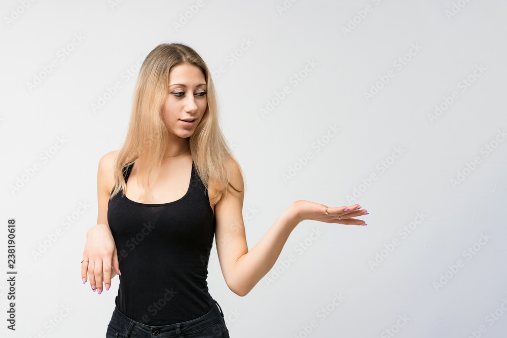 Concept portrait of a beautiful blonde girl smiling on a white background advertises product. She is right in front of the camera and shows different emotions. Concept portrait of a beautiful blonde girl smiling on a white background advertises product. She is right in front of the camera and shows different emotions.