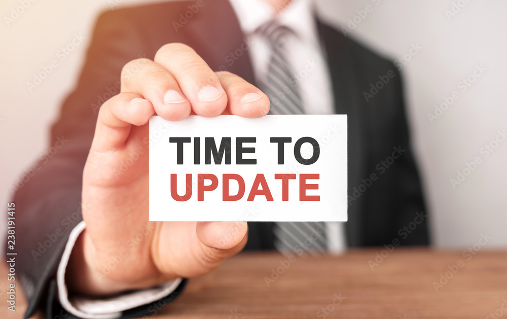 Businessman holding a card with text Time to update Businessman holding a card with text Time to update