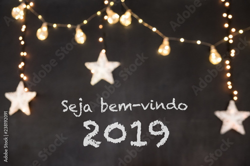 Seja bem-vindo in portuguese means Welcome in a black background with blurred lights and stars. photo