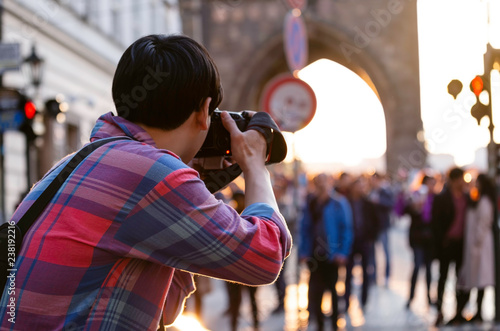 Canvas Print Back view of Street photographer journalist on street in the evening at Charles