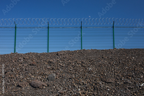 Metal fence with barbed wire.