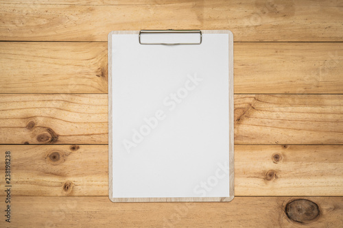 Mock up clip board and white paper on wood background.