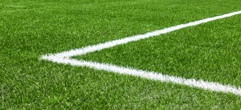Green synthetic artificial grass soccer sports field with white corner stripe line
