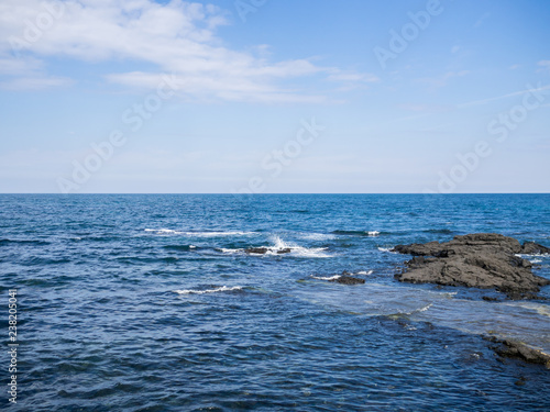 Beautiful blue sea with black sand beach and sky of Jeju island in Korean