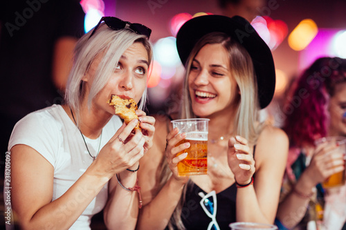 Female friends eating and drinking at music festival