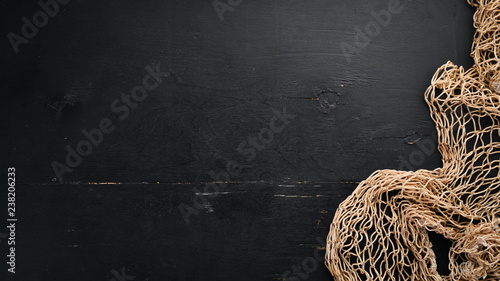 Fishing net on black background. Top view. Free space for your text. photo