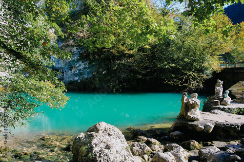 view of the blue lake in Abkhazia with peacocks on the shore.