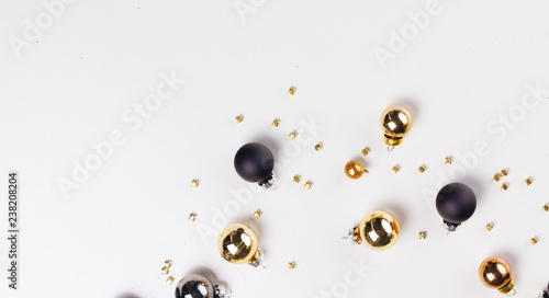 Christmas flat lay scene with golden, gray and black glass balls with copy space over white background