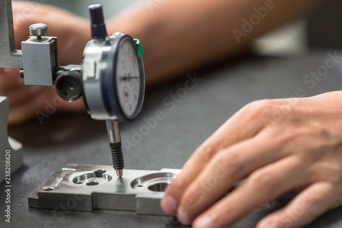 Closed up of measure part precision by dial guage in machinery shop