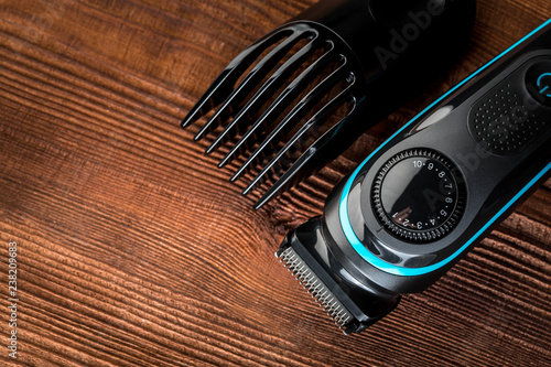 Hair trimmer and scissors on the wooden background. Beard and hair clippers.