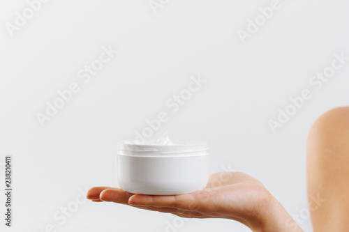 Closeup shot of woman hands holding cream and applying moisturizing hand cream. Beautiful female hands with cream. Hand Skin Care. A woman uses body lotion on your arms. Beauty And Body Care Concept