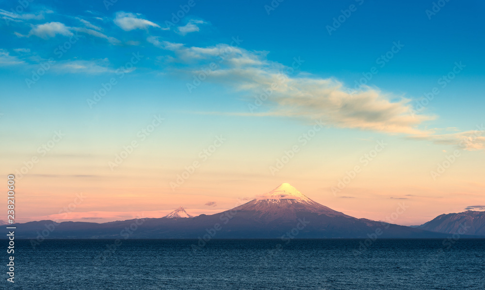 View of Osorno volcano, Puntigudo volcano and Llanquihue Lake in the Chilean Lake district at sunset.