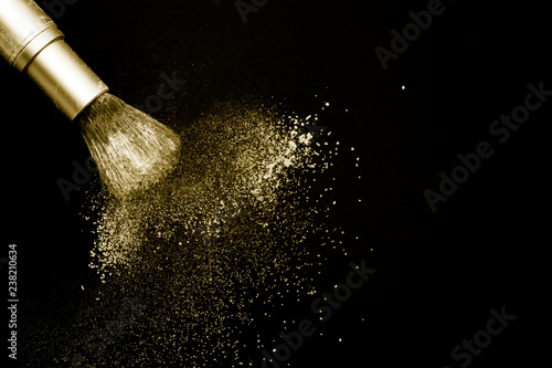 gold powder splash and silver brush for makeup artist or beauty blogger in black background, look like a luxury mood.