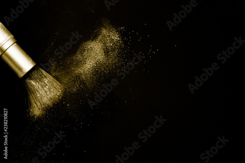 gold powder splash and silver brush for makeup artist or beauty blogger in black background, look like a luxury mood.