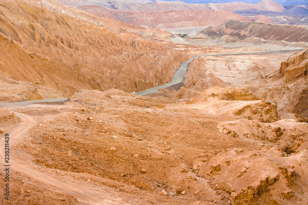 Road in the Atacama desert between salt formations at Valle de la Luna, spanish for Moon Valley, also know as Cordillera de la Sal, spanish for Salt Mountain Range, San Pedro de Atacama, Chile