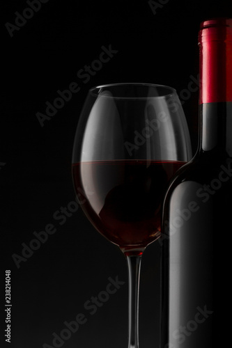 Red wine bottle and glass on the black background