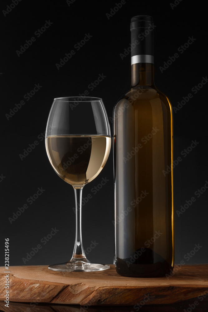 White wine bottle and glass on the black background